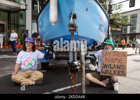 Zwei Mitglieder von Extinction Rebellion DC sitzen während einer Straßenparty, die Teil der Kampagne „End Methan, Electrify DC“ der Gruppe ist, an ein Boot vor dem Hauptquartier von Washington Gas Light angekettet. Die Gruppe protestiert gegen den Ausbau der Infrastruktur für fossile Brennstoffe und die Rolle des Unternehmens bei Methanlecks, die derzeit DC heimsuchen. Methan ist das stärkste Treibhausgas, das die globale Erwärmung antreibt und 80-mal effektiver Wärme einschließt als Kohlendioxid im Laufe von 20 Jahren. (Foto von Allison Bailey/NurPhoto) Stockfoto