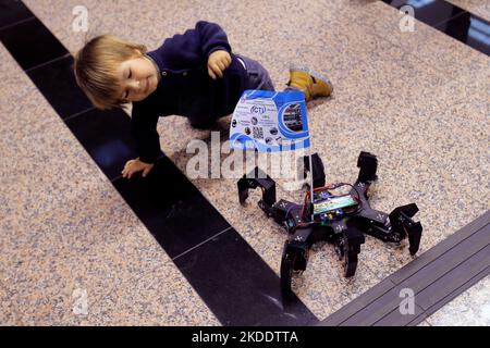 Bukarest, Rumänien. 5.. November 2022. Ein Kind spielt mit einem drahtlos gesteuerten Spider-Roboter, der von Studenten während der ersten Ausgabe des Robofest-Technologiefestivals in Bukarest, der Hauptstadt Rumäniens, am 5. November 2022 vorgestellt wurde. Quelle: Cristian Cristel/Xinhua/Alamy Live News Stockfoto