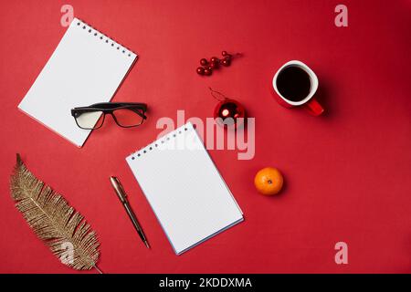 Ein Schreibtisch mit zwei Notizbüchern, Kaffee und weihnachtsschmuck auf dem Tisch, Ansicht von oben Stock Foto Stockfoto