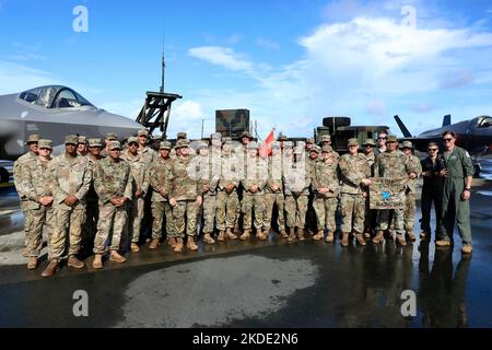 Luftverteidiger von Charlie Battery, 1-1 ADA BN und Mitarbeiter der US-Luftwaffe posieren vor F-35-Flugzeugen, die während des Valiant Shield 22 als Teil der Patriot-Live-Fire-Übung eingesetzt wurden. Das Ziel reiste auf einer Südost-Strecke ins Meer, führte dann eine 180-Grad-Drehung durch und flog von Südosten in Richtung Flughafen. Zu diesem Zeitpunkt wurde das Ziel von zwei Patriot-Abfangraketen PAC-2 im Salvo-Modus aktiviert, wobei der zweite Patriot drei Sekunden nach dem ersten abfeuerte. Die Abfangraketen engagierten das Ziel etwa 35km vor der Küste von Palau in einer Höhe von 10.000 Fuß und spe Stockfoto