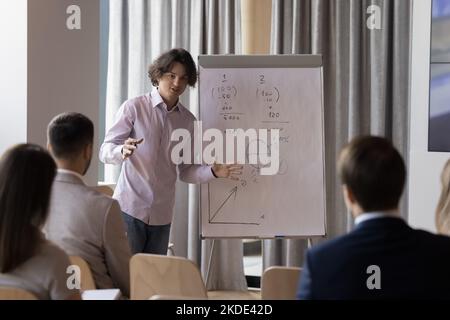 Der junge Business Trainer hält die Präsentation auf einem Flipchart Stockfoto