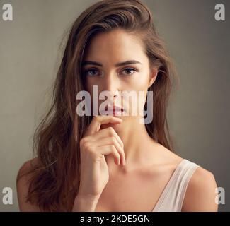 Unvergleichliche Schönheit. Studioportrait einer attraktiven jungen Frau, die vor braunem Hintergrund steht. Stockfoto
