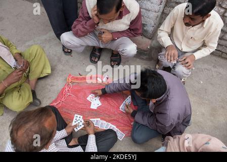 Neu Delhi, Indien, März 11 2017: Reife erwachsene indische Männer spielen Karten im Freien. Freizeitspiele. Aktive Menschen Stockfoto