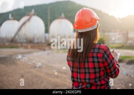 Glückliche asiatische Arbeiter Frau in der Öl-chemischen Industrie arbeiten visuelle Inspektionsliste auf Zwischenablage im Werk Stockfoto