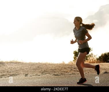 Genießen Sie einen frühen Morgen joggen. Eine sportliche junge Frau auf einen Lauf. Stockfoto