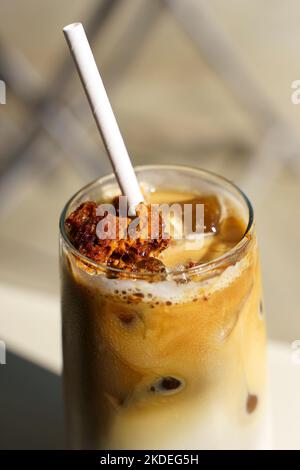 Dalgona Kaffee. Eiskaffeegetränk mit Zucker und Milch auf einer Glastasse auf einem Tisch in einem Café. Trendige kalte Getränke, koreanisches Speisekonzept. Hochwertige Fotos Stockfoto