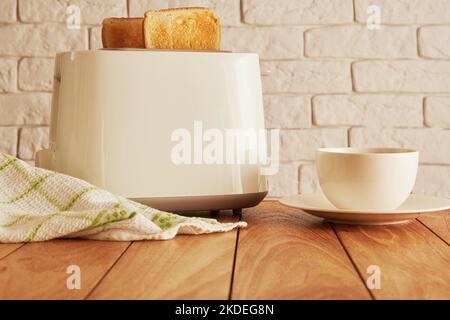 Frisches Frühstück in der Küche. Brot aus dem Toaster und Kaffeetasse. Kochen und Haushaltswaren Technologien Hintergründe Stockfoto