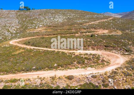 Spektakuläre Luftaufnahme mit Serpentinen-Off-Road-Strecke zum Gipfel des Attavyros-Berges. Höchster Berg auf der Insel Rhodos, Griechenland. Stockfoto