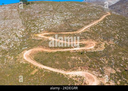 Spektakuläre Luftaufnahme mit Serpentinen-Off-Road-Strecke zum Gipfel des Attavyros-Berges. Höchster Berg auf der Insel Rhodos, Griechenland. Stockfoto