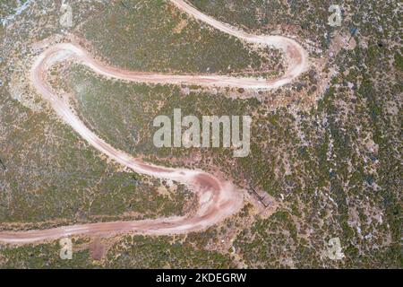 Spektakuläre Luftaufnahme mit Serpentinen-Off-Road-Strecke zum Gipfel des Attavyros-Berges. Höchster Berg auf der Insel Rhodos, Griechenland. Stockfoto