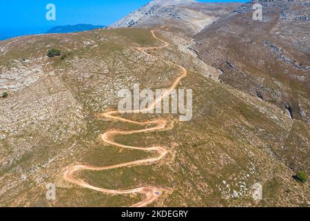 Spektakuläre Luftaufnahme mit Serpentinen-Off-Road-Strecke zum Gipfel des Attavyros-Berges. Höchster Berg auf der Insel Rhodos, Griechenland. Stockfoto