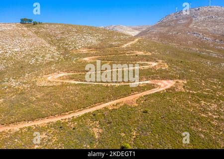 Spektakuläre Luftaufnahme mit Serpentinen-Off-Road-Strecke zum Gipfel des Attavyros-Berges. Höchster Berg auf der Insel Rhodos, Griechenland. Stockfoto