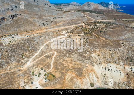 Spektakuläre Luftaufnahme mit Serpentinen-Off-Road-Strecke zum Gipfel des Attavyros-Berges. Höchster Berg auf der Insel Rhodos, Griechenland. Stockfoto