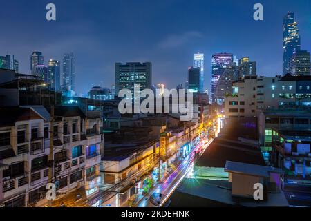 Nachtansicht der Straße im Sathon Bezirk, mit King Power Mahanakhon Turm und Saint Louis Krankenhaus im Hintergrund, Bangkok Stockfoto