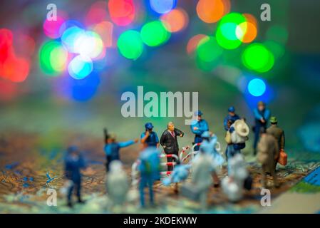 Miniatur Spielzeug Menschen Konzept US-Grenze Patrouillen gegen eine Gruppe von Migranten aus Mexiko-verwischen Bokeh Licht im Hintergrund. Stockfoto