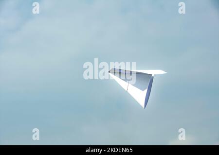 Fliegender weißer Papierflieger Himmel. Reisekonzept. Stockfoto