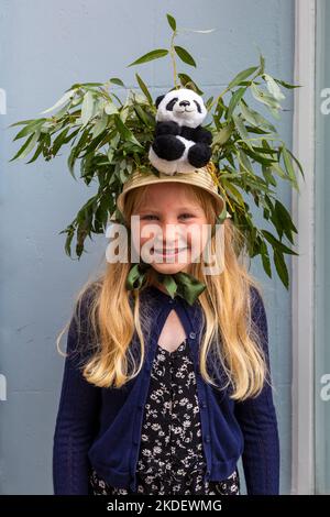 Mädchen mit Hut, Panda und Stöcken beim Bridport hat Festival, Dorset UK im September Stockfoto