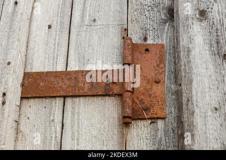 Türscharnier aus rostigem Metall. Türscharnier an einer Holzwand. Stockfoto