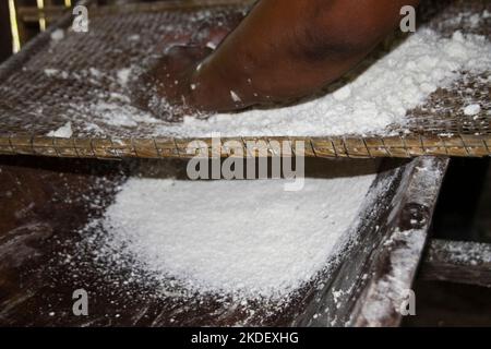 In einem Dorf in Siona im Cuyabeno Wildlife Reserve, Ecuador, demonstriert Woman die Zubereitung und das Kochen von Yucca-Wurzeltortillas in einer Innenküche. Stockfoto