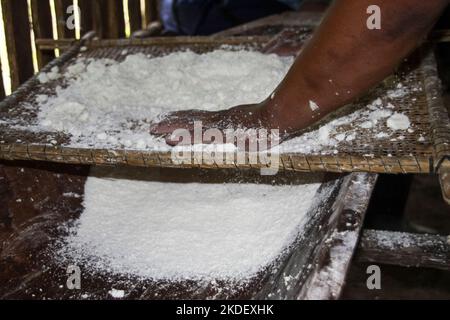 In einem Dorf in Siona im Cuyabeno Wildlife Reserve, Ecuador, demonstriert Woman die Zubereitung und das Kochen von Yucca-Wurzeltortillas in einer Innenküche. Stockfoto