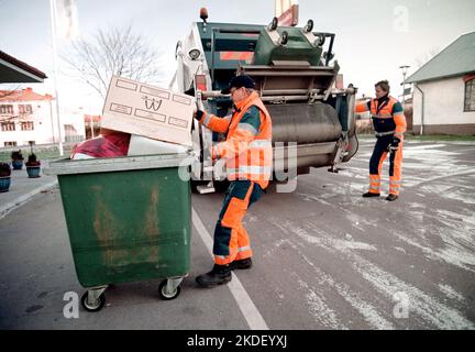 Ein Unternehmen in einer Gemeinde, ein Abfallsammler, auch bekannt als Müllmann, Binman (in Großbritannien), Garbageman oder Müllmann (in den Vereinigten Staaten) während ihrer Arbeit. Stockfoto