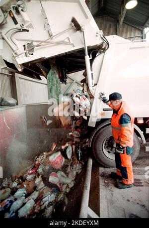 Ein Unternehmen in einer Gemeinde, ein Abfallsammler, auch bekannt als Müllmann, Binman (in Großbritannien), Garbageman oder Müllmann (in den Vereinigten Staaten) während ihrer Arbeit. Stockfoto