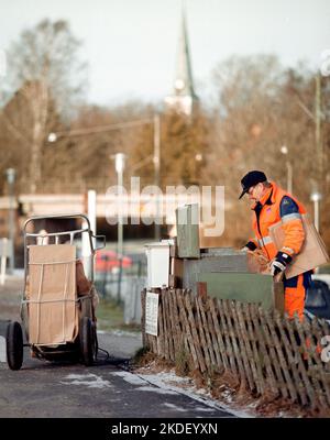 Ein Unternehmen in einer Gemeinde, ein Abfallsammler, auch bekannt als Müllmann, Binman (in Großbritannien), Garbageman oder Müllmann (in den Vereinigten Staaten) während ihrer Arbeit. Stockfoto