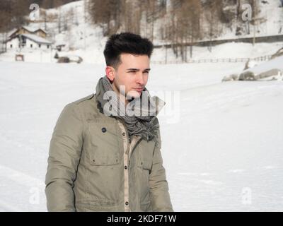 Junger Mann in den Bergen im Winter mit Schnee Stockfoto