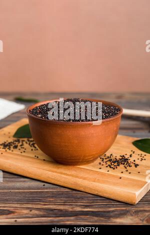 Quinoa-Samen in Schüssel und Löffel auf farbigem Hintergrund. Gesunde kinwa in kleiner Schüssel. Gesundes Superfood. Stockfoto