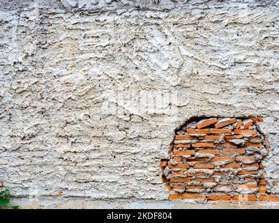 Abstrakte weiße Grunge abblätternde Zementstruktur auf Backsteinwand Hintergrund. Alte Wand aus Rissputz-Beton. Kaputte Steinwand-Tapete. Stockfoto