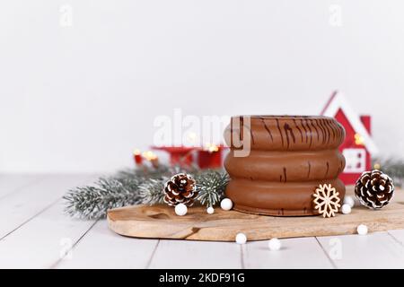 Traditionelle deutsche Winterkuchen mit Schichtenüberzug und Schichtenüberzug im Inneren, genannt „Baumkuchen“, umgeben von saisonaler Dekoration Stockfoto