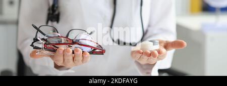 Ärztin, die zwischen Kontaktlinsen und Brillen wählen kann Stockfoto