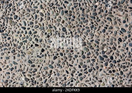 Kieselsteine in Betonstruktur oder Hintergrund Stockfoto