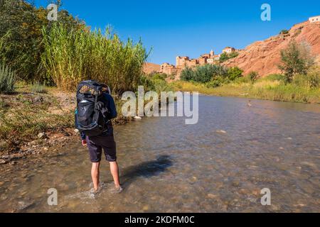 Junger männlicher Trekker in der Nähe des Berberdorfes Tambalouna im Tal der Rosen auf dem M'Goun Gorge Trek im Atlasgebirge von Marokko Stockfoto