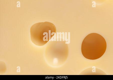 Käse mit großen Löchern, Textur Hintergrund Nahaufnahme. Stockfoto