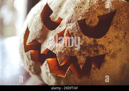 Nahaufnahme eines geschnitzten gruseligen Kürbisses, Halloween Dekoration. Stockfoto