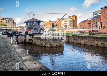 Immobilien am Wasser im Kanal- und Hafengebiet von Leeds City, West Yorkshire, Großbritannien, neben Schleusentoren und der Knights Way Bridge. Stockfoto