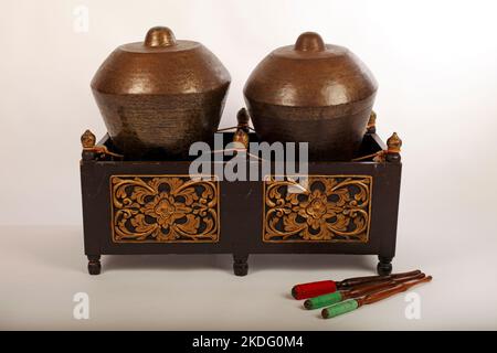 Bonang, ein indonesisches Musikinstrument, das im javanesischen Gamelan verwendet wird. Bronzegange, auf Schnur balanciert, mit dekorativem Holzrahmen. Mit Quirlen. Stockfoto