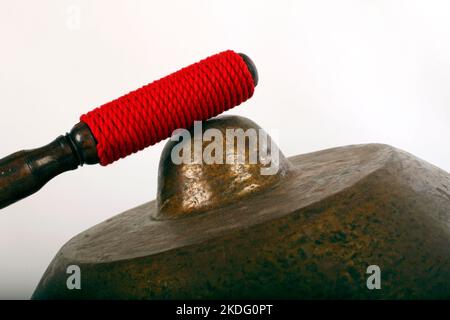 Bonang, ein indonesisches Musikinstrument, das im javanesischen Gamelan verwendet wird. Bronzegange, auf Schnur balanciert, mit dekorativem Holzrahmen. Mit Quirl. Stockfoto