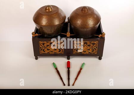 Bonang, ein indonesisches Musikinstrument, das im javanesischen Gamelan verwendet wird. Bronzegange, auf Schnur balanciert, mit dekorativem Holzrahmen. Mit Quirlen. Stockfoto