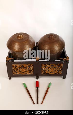 Bonang, ein indonesisches Musikinstrument, das im javanesischen Gamelan verwendet wird. Bronzegange, auf Schnur balanciert, mit dekorativem Holzrahmen. Mit Quirlen. Stockfoto