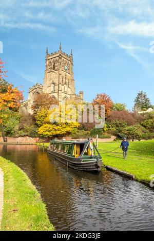 Narrowboat auf dem Staffordshire und Worcester Kanal bei der St. Mary's und All Saints Kirche in der Worcestershire Stadt Kidderminster im Herbst Stockfoto