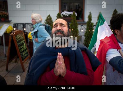 Am 06. November 2022 wird vor dem Campus der Universität Warschau in Warschau, Polen, eine Männergeste als iranisches Lied aufgeführt Stockfoto