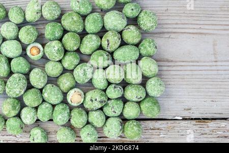 Wasabi-Nüsse liegen auf einer hölzernen Oberfläche Stockfoto