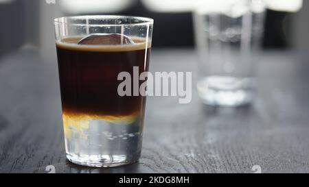 Espresso Tonic im Becher mit Eiskugel, breites Foto Stockfoto