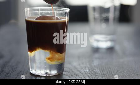 Espresso Tonic im Becher mit Eiskugel, breites Foto Stockfoto