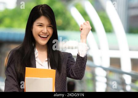 Junge asiatische Frau mit Büchern und lächelnd Blick auf die Kamera in der Universität, Menschen Bildungskonzept. Stockfoto