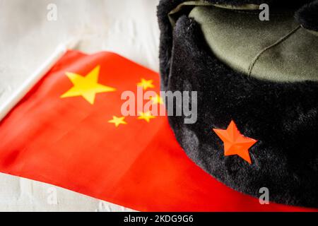 Chinesische Flagge und militärische Deckelung, Konzept, Chinas militärische Expansion und aggressive Politik Stockfoto