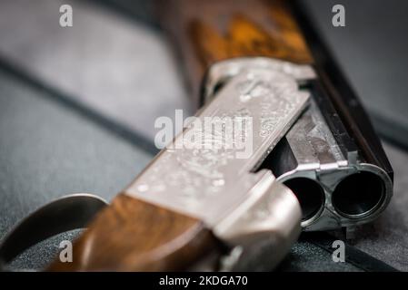 Nahaufnahme von 12 Gauge Shotgun-Action auf einem schlichten Hintergrund für Tontaubenschießen oder Wildjagd Stockfoto