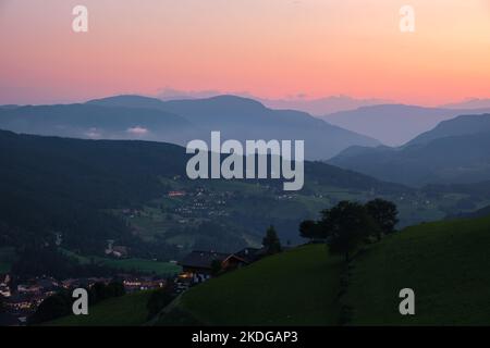 Blick von der Bergstadt Seis auf das Eisacktal bei Sonnenuntergang in Südtirol Italien. Stockfoto